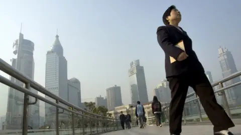 BBC woman in suit walking across bridge