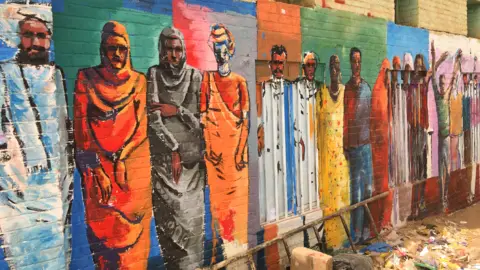 BBC A mural of Sudanese people on a wall in Khartoum, Sudan