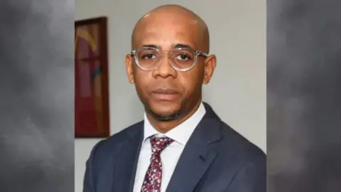 Baltasar Ebang Engonga / Facebook A head and shoulders image of Baltasar Ebang Engonga wearing a blue suit, white shirt and patterned tie.