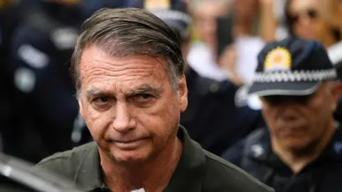 Former Brazilian President Jair Bolsonaro leaves the hospital where he went to undergo a skin surgery procedure, authorized by Supreme Court Justice Alexandre de Moraes, leaving the house arrest after being convicted by a Supreme Court majority of plotting a coup to remain in power after losing the 2022 election, in Brasilia, Brazil, September 14, 2025.
