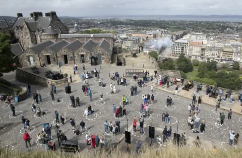 Jane Barlow / PA Media Visitors at Edinburgh Castle standing socially distanced in marked out circles