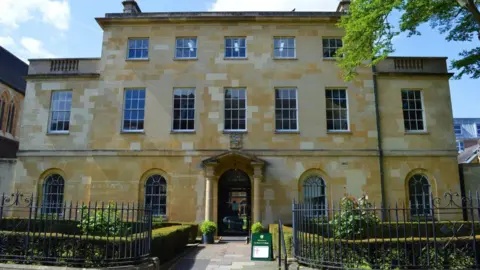 Getty Images St Peter's College is a large georgian style stone building with a tidy garden in front of it.
