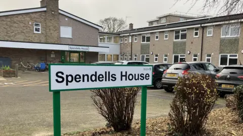 A building with a sign in the foreground saying "Spendells House"