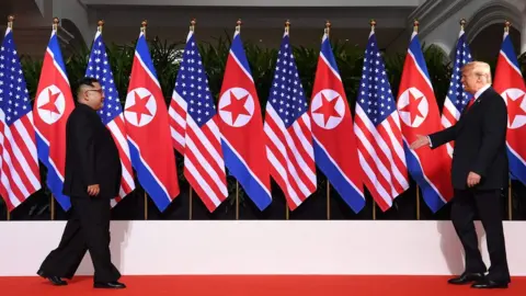 AFP US President Donald Trump (R) and North Korea"s leader Kim Jong Un (L) walk toward one another at the start of their historic US-North Korea summit, at the Capella Hotel on Sentosa island in Singapore on June 12, 2018.