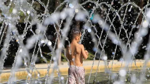 EPA A boy takes a bath in a fountain in Madrid Rio park, in Madrid, Spain, 01 August 2018.