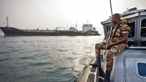 Getty Images An anti-piracy team watches over a cargo ship off the coast of West Africa.