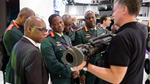 Getty Images A group from the Botswana military are shown weapons by the SAAB team