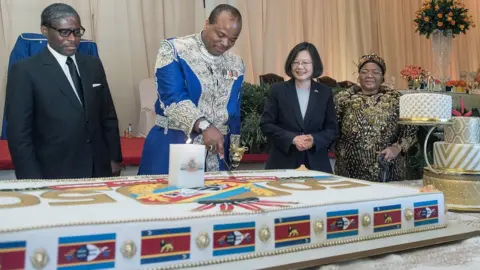 Taiwan presidential office A handout photo made available by Taiwan's Presidential Office shows Taiwan's President Tsai Ing-wen (2-L) watching Swaziland's King Mswati III (2-R) cutting a birthday cake to celebrate 50th anniversary of independence and his 50th birthday in Manzini, Swaziland, 19 April 2018