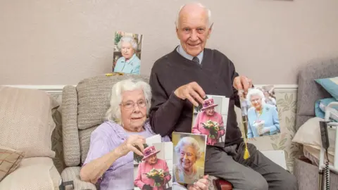 The News, Portsmouth Ivy and John Winn hold pictures of the Queen