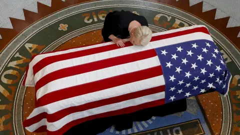 Getty Images Cindy McCain kisses her husbands coffin in Arizona.