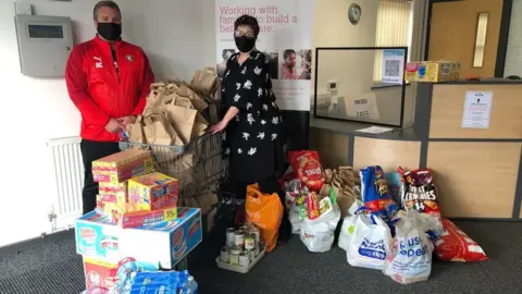 Faces Wendie Harvey with man and food donations