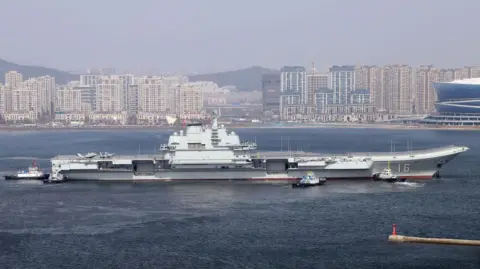 Getty Images Aircraft carrier Liaoning sets for sea trial at Dalian shipyard with the help of towboats after on February 29, 2024 in Dalian, Liaoning Province of China.