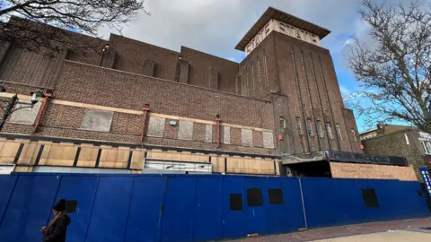 Simon Dedman/BBC An old building boarded up with blue fencing