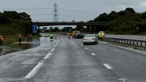 Avon Fire and Rescue The M5 with an abandoned car and significant flooding on the hardshoulder, with fire and rescue crews dealing with the incident