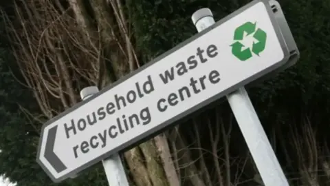 A street sign reading "household waste recycling centre".