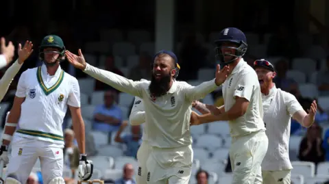 Getty Images Moeen Ali next to Alastair Cook and Ben Stokes in cricket whites with his arms wide, appealing for a wicket