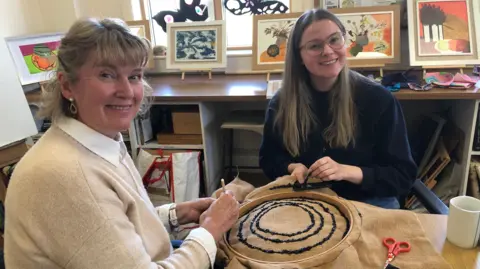 BBC / Naj Modak Mel and Ella Spanton are pictured with some hessian cloth