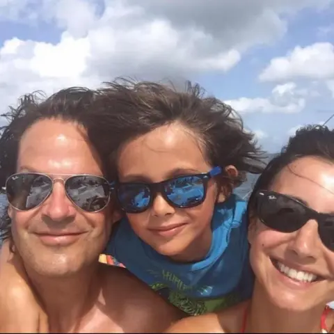 Lucy Owen Lucy Owen (right) with her husband Rhodri and their son Gabriel, wearing sunglasses with their arms around each other, smile for a selfie