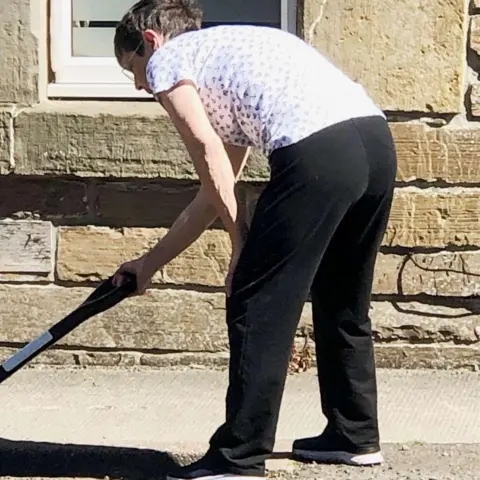 SWNS Jenny Paterson at work on the potholes