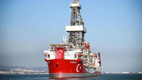 A ship with the colour of the Turkish flag sailing in the ocean
