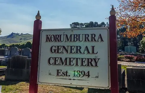 Sign of Korumburra General Cemetery Est. 1984 with headstones in the background