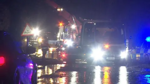 Lorry being removed from water by crane