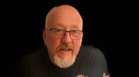 Space North East Ralph Dinsley. He is bald and has a grey goatee. He is wearing black-rimmed glasses.