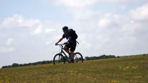 BBC A man cycling down a hill