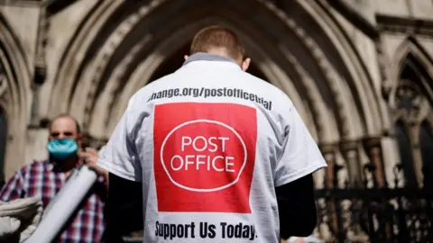 Getty Images The back of a man walking into a court, with a T-shirt that asks people to support victims of the Horizon scandal