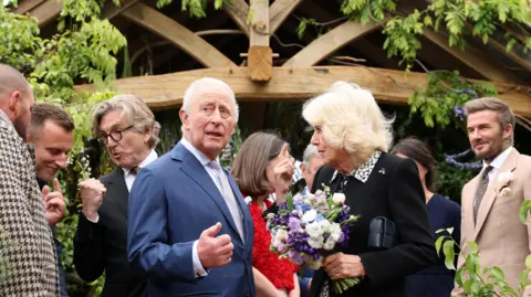 PA King Charles III and Queen Camilla, watched by Sir David Beckham (right) view the RHS and The King's Foundation Curious Garden