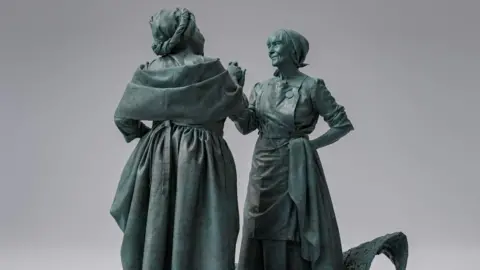 Rachel Carter Design of statue showing two women holding hands while greeting each other in the 19th Century