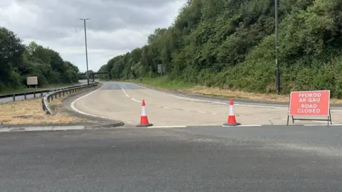 A dual carriageway with a red sign that says road closed.