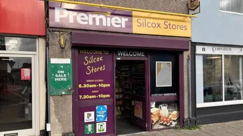 A Premier store with Silcox Stores written on the shop front indicating it's owner name.