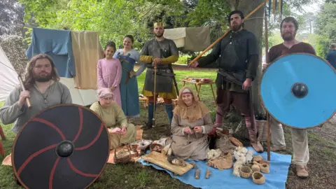Louise Parker/BBC A group of men, women and children in Anglo-Saxon outfits.