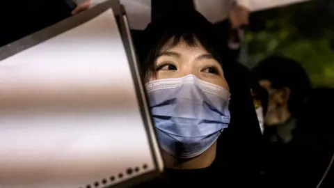 Getty Images A protester holds a blank piece of paper