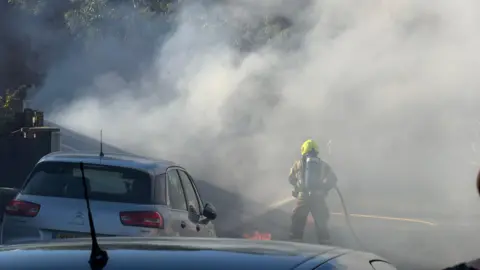 Emma Snow/ BBC Firefighter tackling a blaze