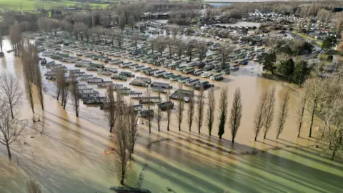 PA Media Holiday homes at Billing Aquadrome surrounded by water after Storm Henk in 2024