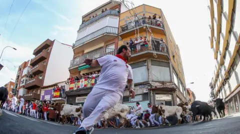 People run in front of bulls in San Sebastian de los Reyes city, Madrid province, central Spain, 1 September 2023.