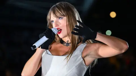 Taylor Swift on stage in a white top