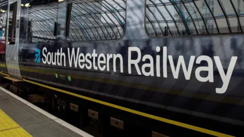 A blue train with the words "South Western Railway" on the side of it.