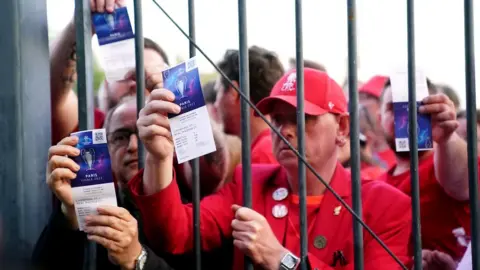 PA Media Liverpool fans stuck outside the ground show their match tickets during the Uefa Champions League Final at the Stade de France, Paris