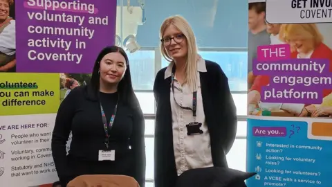 An information stall with two women stood looking at the camera