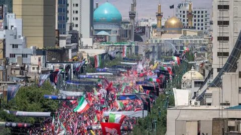 Thousands of mourners gather on a boulevard in Mashhad, north-eastern Iran, ahead of the burial of Iran's late Supreme Leader Ayatollah Ali Khamenei (9 July 2026)