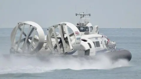 With two large fans and seawater spray from its black rubber skirts the hovercraft "Solent Flyer" leaves Clarence Pier at Southsea heading for the Isle of Wight 