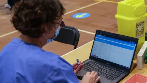 Getty Images A nurse checking booster vaccine vials