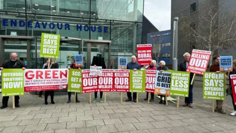 Ben Parker/BBC Protesters in Ipswich holding signs