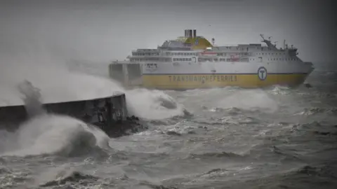 BBC A white and yellow ferry on rough water leaving a harbour.