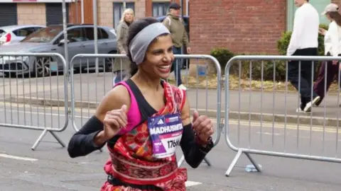 Madhusmita Jena runs in her brightly coloured red and patterned sari. 