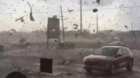 A car surrounded by flying debris 