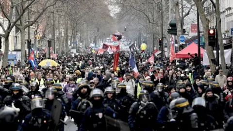 Getty Images French anti-riot policemen lead the march as protesters demonstrate in Paris, on January 11, 2020